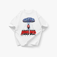 Oversized white heavyweight T-shirt featuring a large front graphic inspired by Mobb Deep and Akira. The artwork shows a lone figure in a red jersey walking toward a blue modified car from an overhead perspective, referencing iconic anime and hip-hop imagery. Bold distressed typography reads “The Infamous Shook Ones Part,” with FKONYC branding incorporated into the design. Product shown on a clean white background.